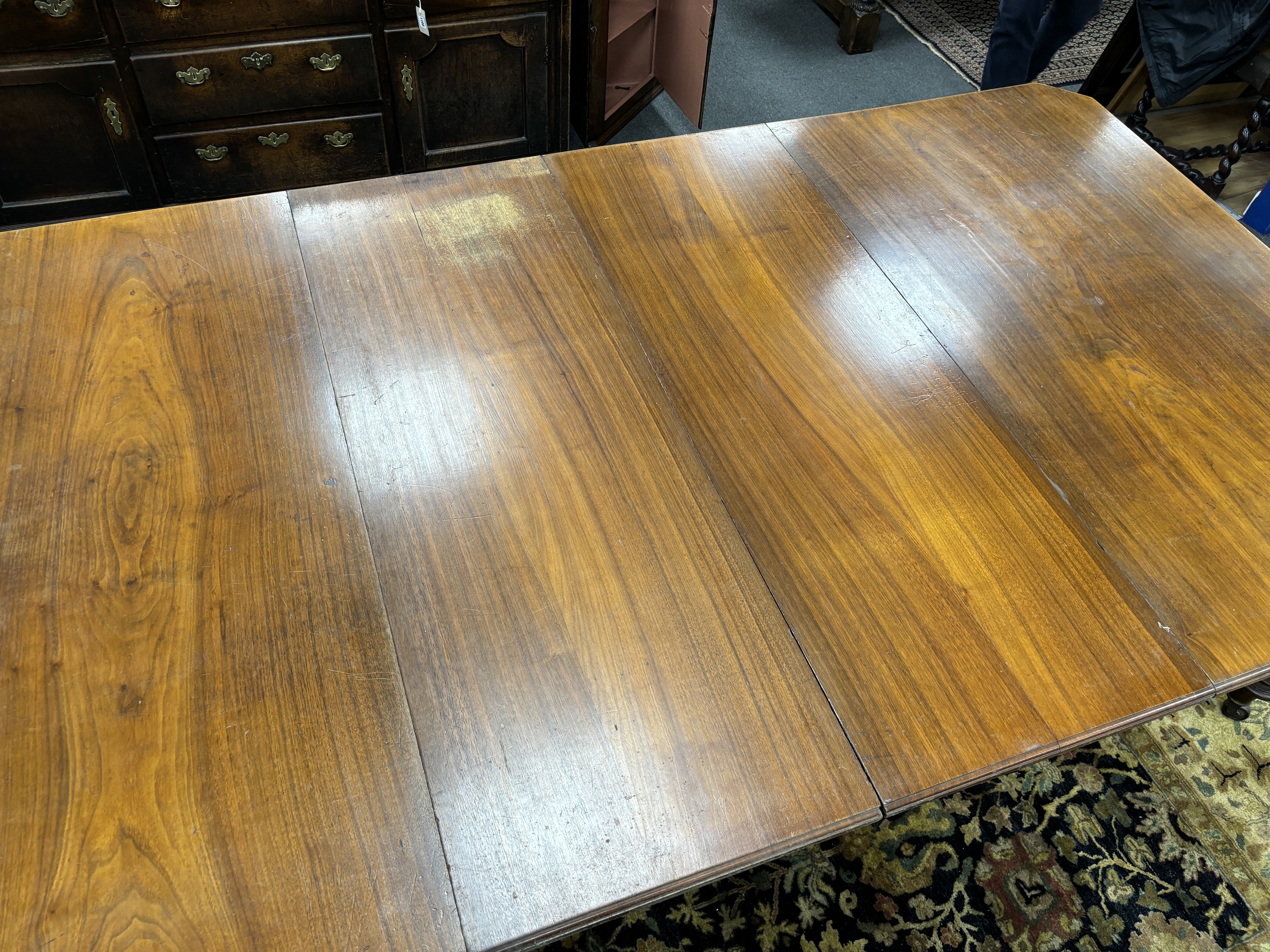 A late Victorian walnut extending dining table, on turned fluted baluster legs, 240cm extended, two spare leaves, depth 137cm, height 73cm